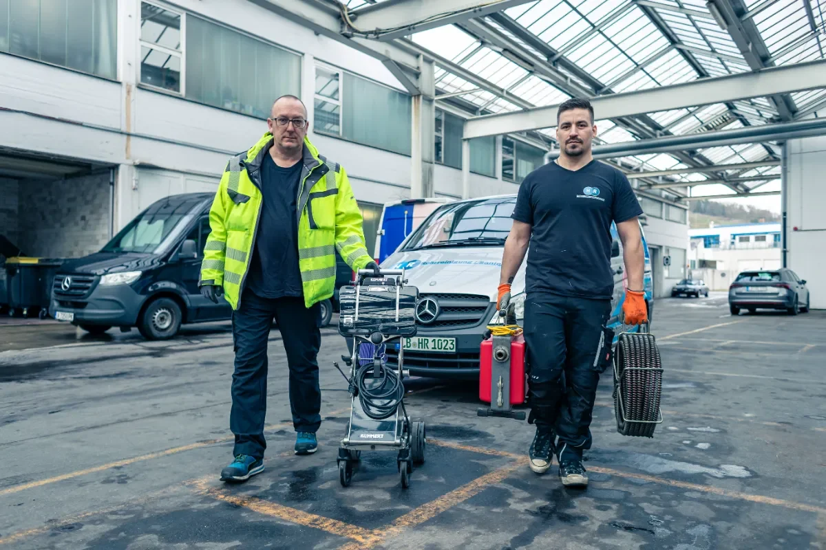 Techniker der HR Rohrreinigung/Sanierung mit Werkzeug am Einsatzfahrzeug